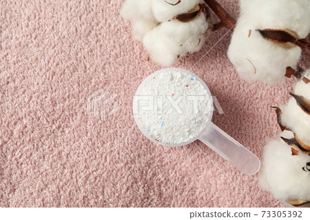Scoop with washing powder and cotton on towel background Scoop with washing powder and cotton on towel background 73305392