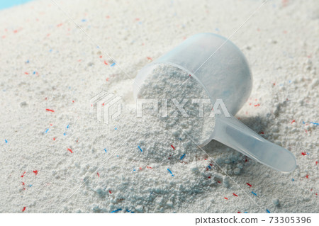 Scoop with washing powder on washing powder background Scoop with washing powder on washing powder background 73305396