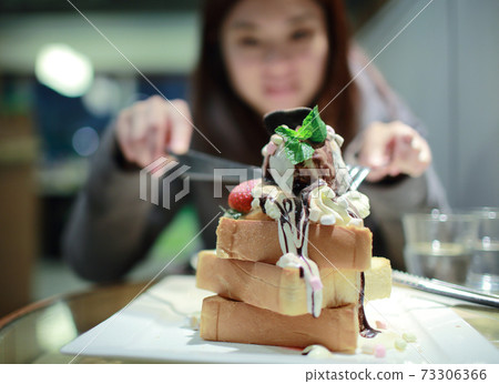 asian girl as a gourmet to taste the dessert 73306366