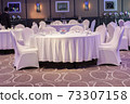 Decoration of tables and chairs in a hotel interior. Whtie textile. Empty table and chairs. 73307158