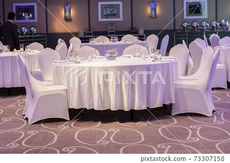 Decoration of tables and chairs in a hotel interior. Whtie textile. Empty table and chairs. 73307158