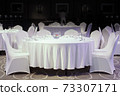 Decoration of tables and chairs in a hotel interior. Whtie textile. Empty table and chairs. 73307171