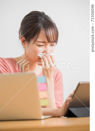 A young woman who has a runny nose due to hay fever 73308096