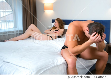 Husband and wife in their underwear on the bed had a fight with each other. Husband and wife in their underwear on the bed had a fight with each other. 73308540