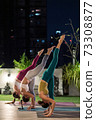 Asian weman group do yoga in city at night 73308877