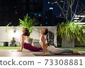 Asian women do yoga in city at night 73308881