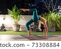 Asian woman do yoga in city at night 73308884