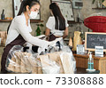 Waitress with face mask prepare order for curbside pick up and takeout. 73308888
