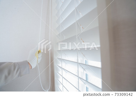 Hands of workers installing blinds on windows Hands of workers installing blinds on windows 73309142