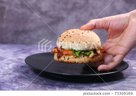 hand holding beef burger on table close up hand holding beef burger on table close up 73309169