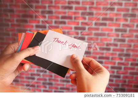 women's hand holding thank you letter rear view women's hand holding thank you letter rear view 73309181
