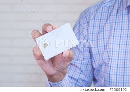 Man in casual dress showing credit card  73309192