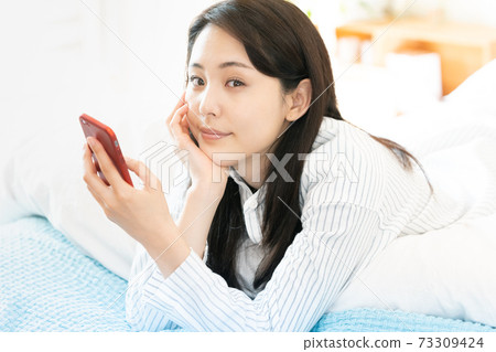Young woman looking at a smartphone Young woman looking at a smartphone 73309424