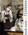 Waitress with face mask take order for curbside pick up and takeout. 73309444