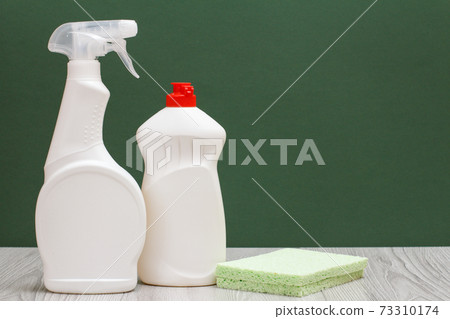 Bottles of dishwashing liquid and sponge on the green background. Bottles of dishwashing liquid and sponge on the green background. 73310174