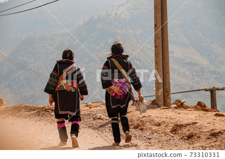 Women from the Hmong tribe wearing their traditional clothes while walking back to Lao Cai Village in Sa pa, Vietnam 73310331
