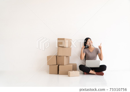 Happy Asian young entrepreneur, Smile for sales success and pointing finger up at the home office and store, Concept of merchant  business online, eCommerce and delivery and lifestyle 73310756