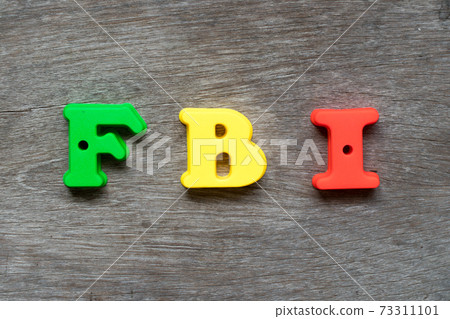 Colorful plastic alphabet in word FBI (Abbreviation of Federal Bureau of Investigation) on wood background 73311101