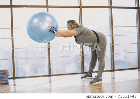 Adult fat woman doing gymnastics at the gym Adult fat woman doing gymnastics at the gym 73311448