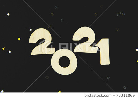 Wooden numbers 2021 on a black background. Wooden numbers 2021 on a black background. 73311869