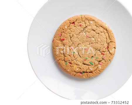 Almond giant biscuits with coloured sugar pieces on a white platter Almond giant biscuits with coloured sugar pieces on a white platter 73312452