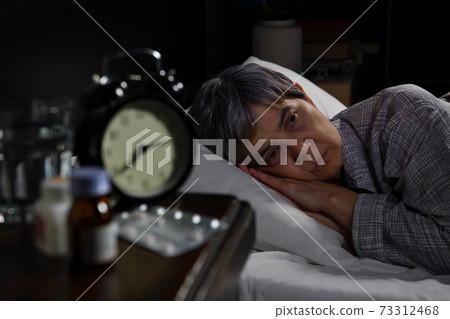 Depressed senior woman lying in bed cannot sleep from insomnia 73312468