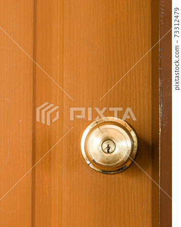 Circle door knob and  brown wood door. 73312479