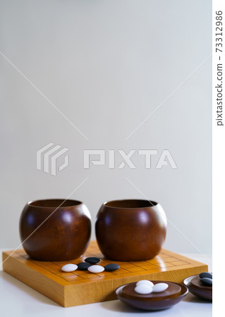 black and white stones on wooden board (goban, baduk, weiqi board game) black and white stones on wooden board (goban, baduk, weiqi board game) 73312986