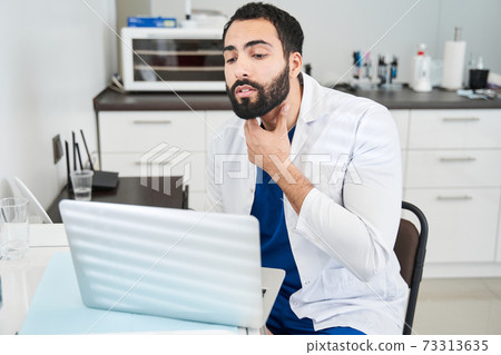 Doctor gesturing and showing something while consulting patient 73313635