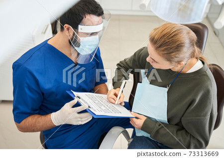 Doctor is discussing something with his female cute patient 73313669
