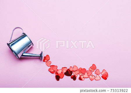silver watering can pouring hearts on a pink background. Valentines background, love, date concept 73313922