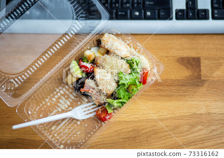 Delivery of takeout meal salad to workplace 73316162