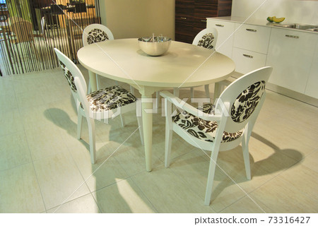 Modern lacquer kitchen, wooden white dining table and white chairs 73316427