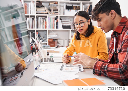 Designers wearing casual clothes are sitting at the coworking 73316710