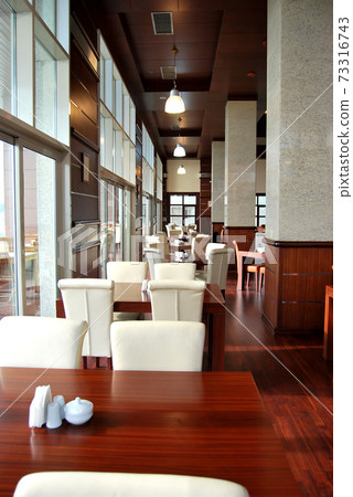 Ornate empty dining tables in a modern restaurant ready to serve 73316743