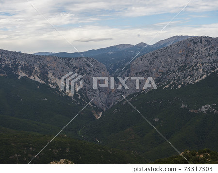 Aerial View of green forest landscape of Supramonte Mountains with famous hiking destinantion Gola Su Gorropu gorge, limestone rock and mediterranean vegetation, Nuoro, Sardinia, Italy. 73317303