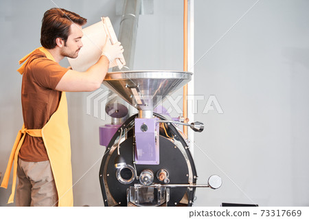 Worker pouring coffee beans in case Worker pouring coffee beans in case 73317669