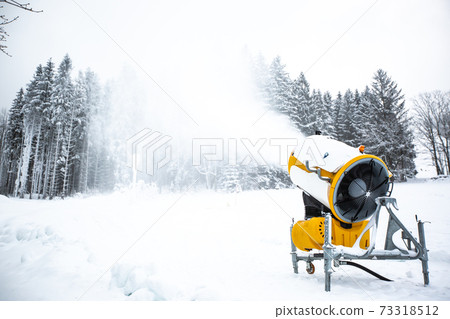 Snow cannon, machine or gun snowing the slopes or mountain for skiers ans snowboarders, artificial snow Snow cannon, machine or gun snowing the slopes or mountain for skiers ans snowboarders, artificial snow 73318512