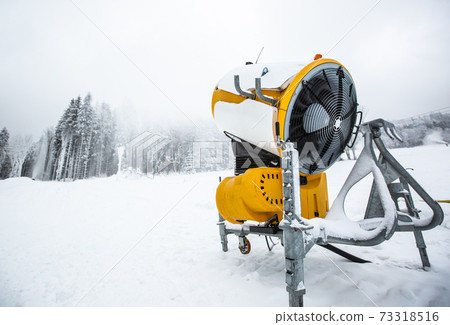 Snow cannon gun, artificial snow making machine on the slopes of a ski  resort, ski lift and piste Stock Photo - Alamy