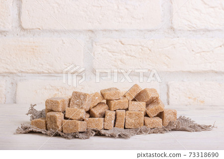 Pricked brown cane sugar on linen cloth 73318690