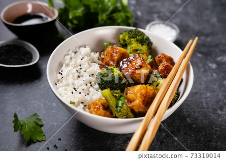 Asian vegan bowl with rice, broccoli and fried tofu 73319014