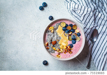 Acai smoothie bowl with chia seeds, berries, nuts and peanut butter, top view. Healthy breakfast concept. 73319083
