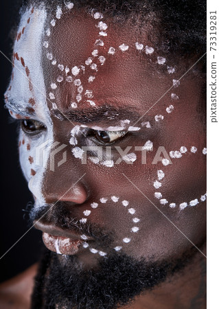 thoughtful african man with ethnic make-up stand thinking looking down thoughtful african man with ethnic make-up stand thinking looking down 73319281