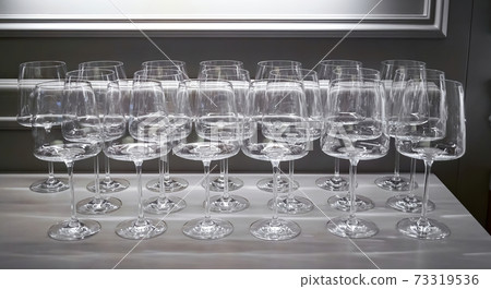 lot of wine glasses in a row. Empty clean glasses wine, water in a kitchen of a restaurant or cafe. Catering buffet in restaurant room. Concept preparing for celebration lot of wine glasses in a row. Empty clean glasses wine, water in a kitchen of a restaurant or cafe. Catering buffet in restaurant room. Concept preparing for celebration 73319536