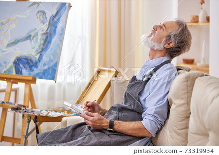 a man artist is waiting for a muse to create a masterpiece, immersed in thought a man artist is waiting for a muse to create a masterpiece, immersed in thought 73319934