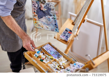 cropped photo of male artist man in apron during work process cropped photo of male artist man in apron during work process 73319975