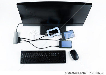 Multiple external hard drives connected to a monoblock on a white background.Computer with hard drive 73320632