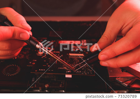 computer hardware engineering. developer soldering electronic component computer hardware engineering. developer soldering electronic component 73320789