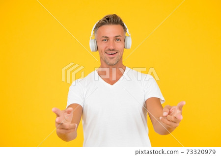 Happy middle-aged man in headphones point fingers  73320979
