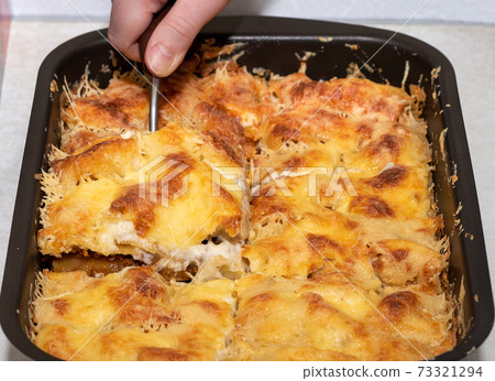 A serving of lasagna on a scoop. Making lasagna at home. 73321294